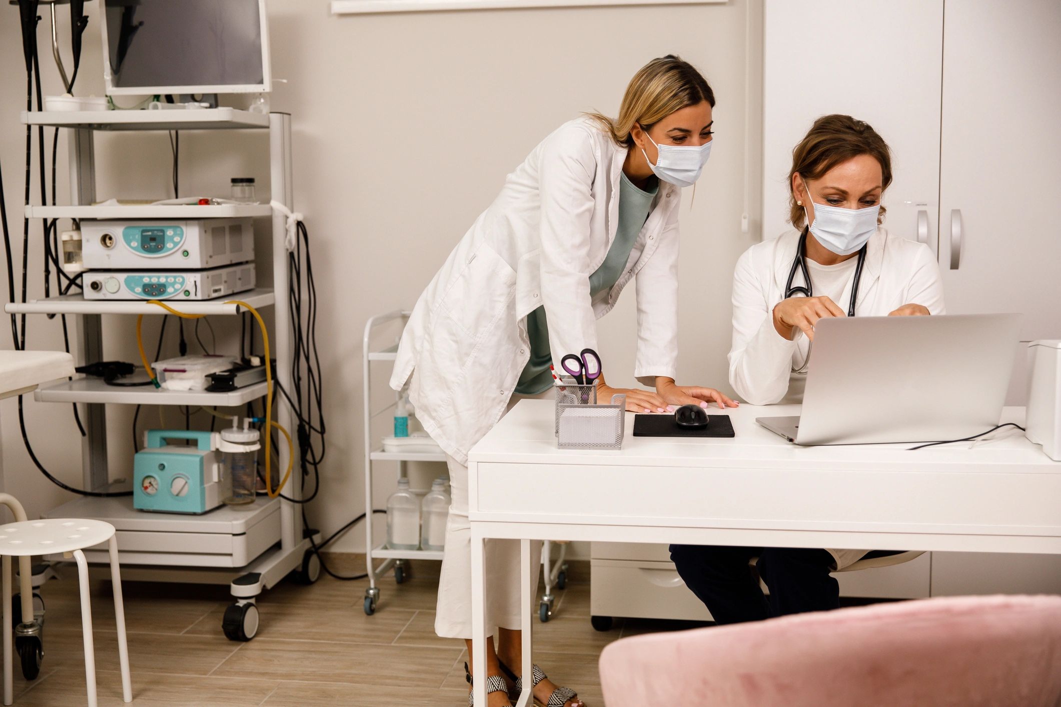 Two doctors reviewing a medical record on a laptop
