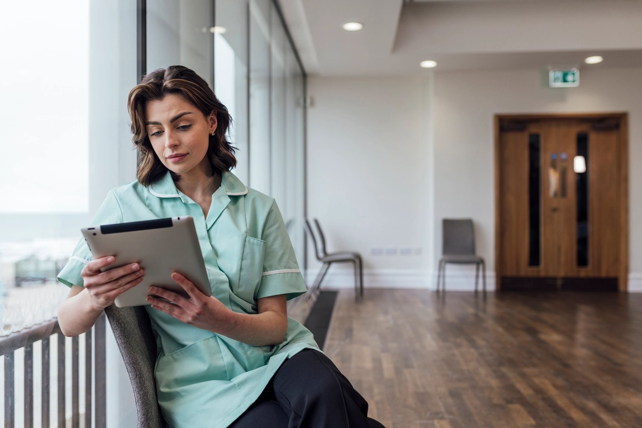 Healthcare professional reviewing records on a digital tablet