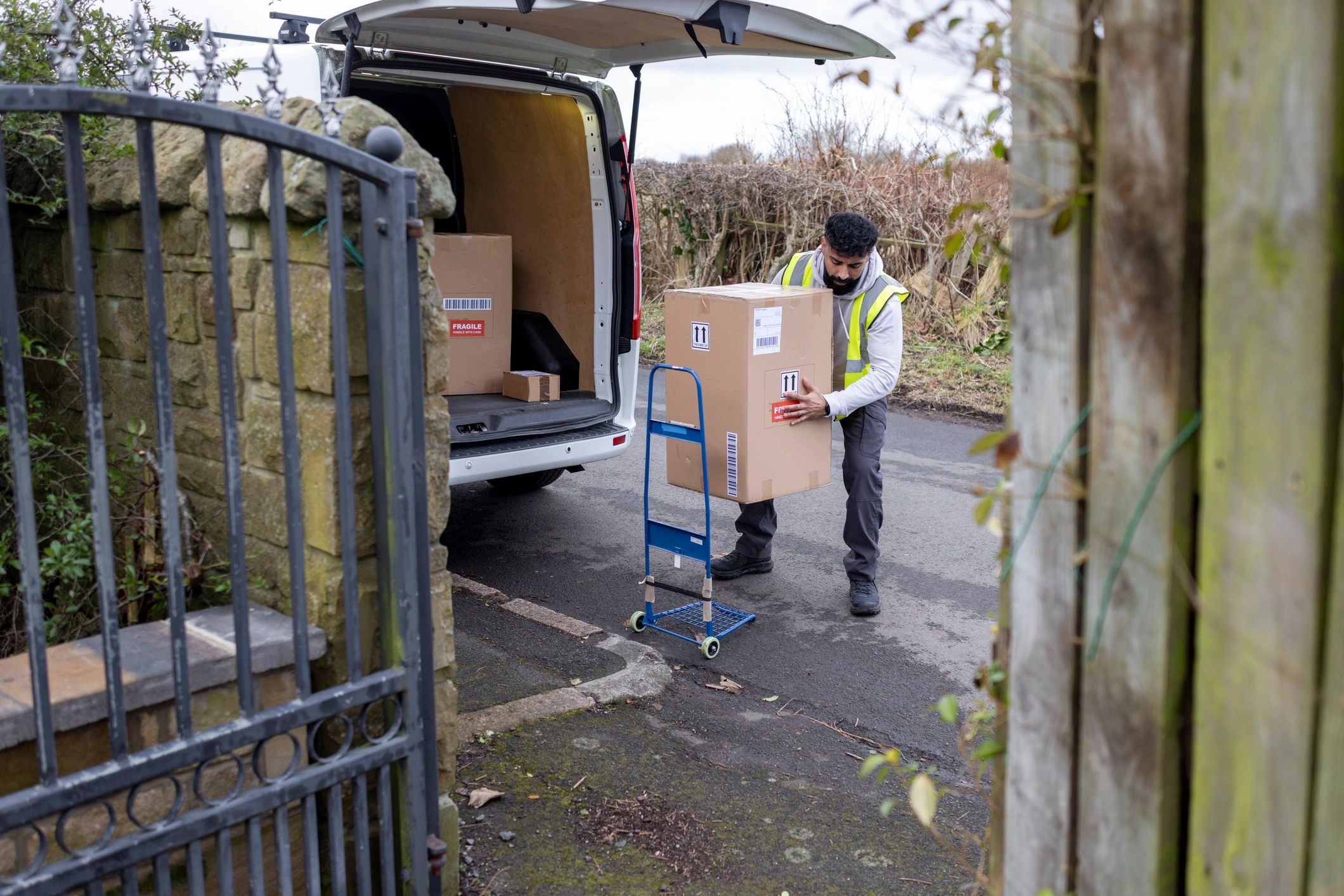 Delivery driver unloading packages from a van