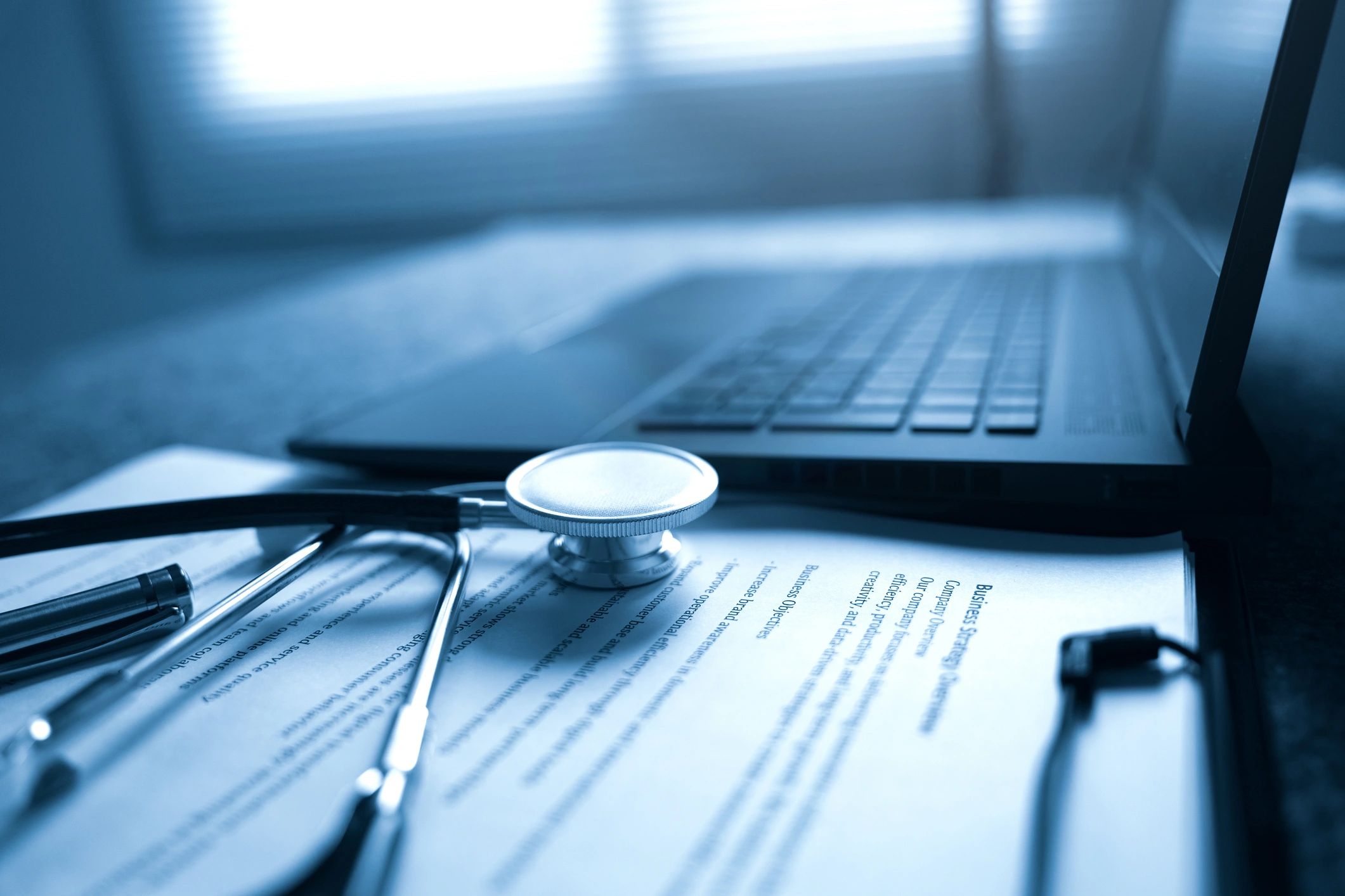 Medical workspace with documents and laptop